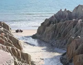 Bonita praia de Canoa com buggy passando na beira do mar